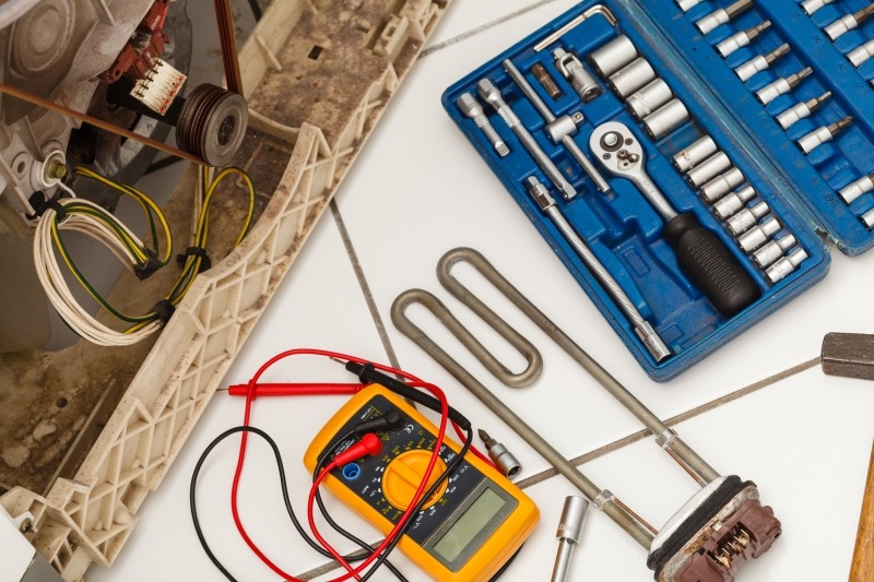 Engineer repairing a washing machine in Fulham